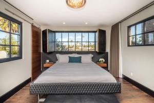 Un dormitorio con una cama grande con dos ventanas. en Walk to the Beach Luxury Roof Deck Sunset View, en Oceanside