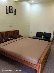 a large bed in a room with a laptop on it at Greens home stay in Yelagiri