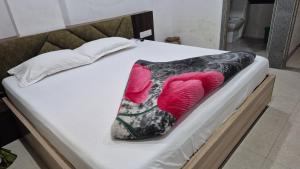a bed with a black and pink pillow on it at Baba Shyam hotel in Rīngas
