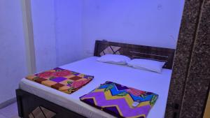 a bed with two pillows on top of it at Baba Shyam hotel in Rīngas +2 photos
