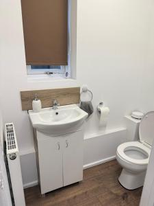 een witte badkamer met een wastafel en een toilet bij EM HOME - Room 4 in Nottingham