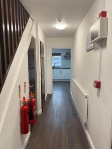 een gang met een rode brandkraan en een trap bij EM HOME - Room 4 in Nottingham +1 foto
