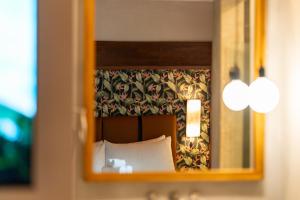 a mirror of a hotel room with a bed and a curtain at Suwa Villa Arenal in Fortuna +75 photos