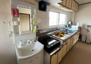 una piccola cucina con lavello e fornello di Furano House, 1F Apartment, 2 Bedrooms, Max 8PP - 6 Adults 2 Kid, Near JR, Group Travel, Onsite Parking a Furano