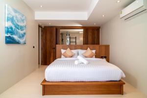 a bedroom with a large bed with white sheets at Baan Bophut Beach Hotel Samui - SHA Extra Plus in Bophut