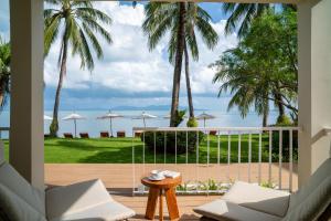 a view from the living room of a resort with palm trees at Baan Bophut Beach Hotel Samui - SHA Extra Plus in Bophut