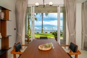 a dining room with a table and a view of the ocean at Baan Bophut Beach Hotel Samui - SHA Extra Plus in Bophut