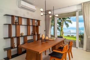 a dining room with a wooden table and chairs at Baan Bophut Beach Hotel Samui - SHA Extra Plus in Bophut