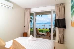 a bedroom with a bed and a view of the ocean at Baan Bophut Beach Hotel Samui - SHA Extra Plus in Bophut