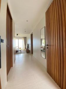 a hallway with a wooden door and a living room at Baan Bophut Beach Hotel Samui - SHA Extra Plus in Bophut