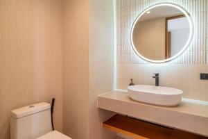 a bathroom with a white sink and a mirror at Baan Bophut Beach Hotel Samui - SHA Extra Plus in Bophut