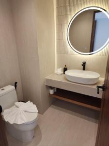 a bathroom with a sink and a toilet and a mirror at Baan Bophut Beach Hotel Samui - SHA Extra Plus in Bophut