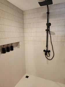 a shower with a shower head in a bathroom at Baan Bophut Beach Hotel Samui - SHA Extra Plus in Bophut