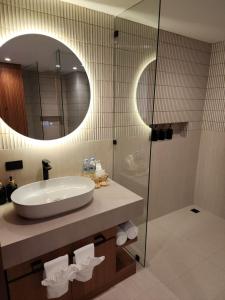 a bathroom with a sink and a shower with a mirror at Baan Bophut Beach Hotel Samui - SHA Extra Plus in Bophut