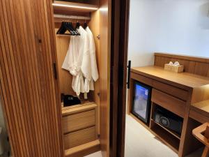 a room with a closet with a tv and a door at Baan Bophut Beach Hotel Samui - SHA Extra Plus in Bophut