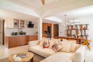 a living room with a couch and a kitchen at Baan Bophut Beach Hotel Samui - SHA Extra Plus in Bophut