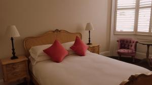 a bedroom with a bed with red pillows and a chair at Red Brighton Blue in Brighton & Hove