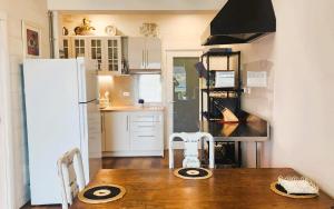 a kitchen with a wooden table and a white refrigerator at Waterfront Abode - 2 bedrooms in Hobart