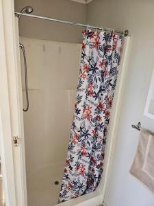 a shower curtain with a floral pattern in a bathroom at On Tate in Waitara +10 photos