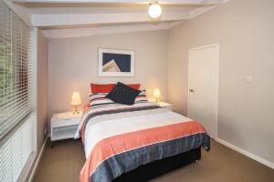 a bedroom with a bed and two night stands with lamps at Karri Birdsong Retreat in Margaret River Town
