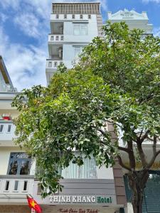 a white building with a tree in front of it at Thinh Khang Hotel Vung Tau in Vung Tau
