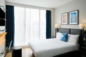 泰恩河畔纽卡斯尔Four Points Flex by Sheraton Newcastle的一间卧室，里面有一张床和一扇大窗户。