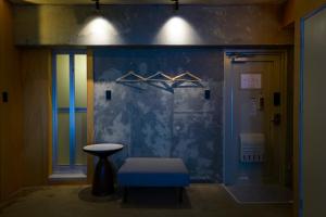 福岡市にあるウクネ Hotel UKUNEのスツールと青い壁のある部屋