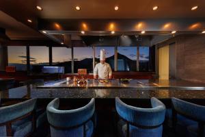 a chef standing behind a counter in a kitchen at Kokusai 21 International Hotel in Nagano