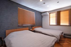a bedroom with two beds and two windows at Gold Valley Villa A in Futtsu