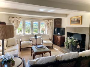 ein Wohnzimmer mit weißen Möbeln und einem Kamin in der Unterkunft Woodlea Cottage in Huddersfield