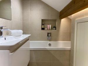 ein Badezimmer mit Waschbecken und Badewanne in der Unterkunft Woodlea Cottage in Huddersfield + 33 Fotos