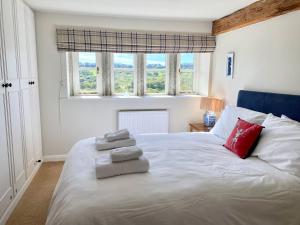 ein Schlafzimmer mit einem großen weißen Bett mit Handtüchern darauf in der Unterkunft Woodlea Cottage in Huddersfield