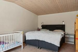 - une chambre avec un grand lit et un lit bébé dans l'établissement Charming Holiday Home In Peaceful Surroundings, à Gedser