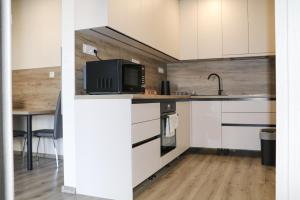 a kitchen with white cabinets and a tv on a counter at Apartmán Wellness-Detva in Detva