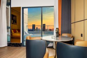 a dining room with a table and a view of a city at Oakwood BLEXUS Apartment Sanya in Sanya