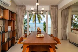 a living room with a wooden table and chairs at Baan Bophut Beach Hotel Samui - SHA Extra Plus in Bophut