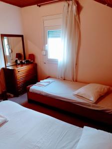 a bedroom with two beds and a window at ORFANIDISHAUS 300 m απο παραλια ΟΡΦΑΝΙΟΥ - in Orfánion