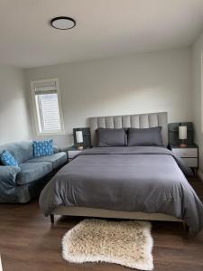 a bedroom with a large bed and a couch at Exquisite Entire 4- Bed rooms vacation home! in Calgary