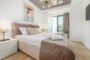 a white bedroom with a large bed and a window at Astria Siena - Complex Novum in Olimp