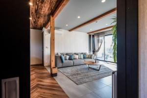 a living room with a couch and a table at Gold Valley Villa B in Futtsu