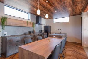 a kitchen with a large wooden table and chairs at Gold Valley Villa B in Futtsu