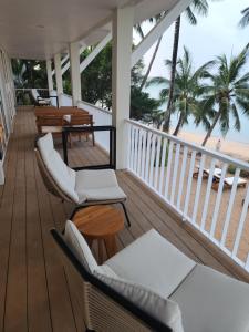 a porch with chairs and tables and the beach at Baan Bophut Beach Hotel Samui - SHA Extra Plus in Bophut