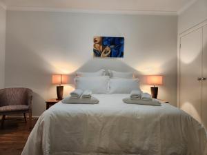 伯威克Beaumont Waters Unit,2 bedrooms,3 beds的卧室里有一张白色的床，床上有两条毛巾