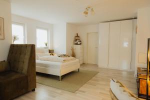 une chambre avec un lit, un canapé et une chaise dans l'établissement 40qm Wohlfühl-Apartment im Grünen mit Sorglospaket, à Wuppertal