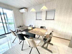 a dining room with a table and chairs at Gold Valley Villa C in Futtsu