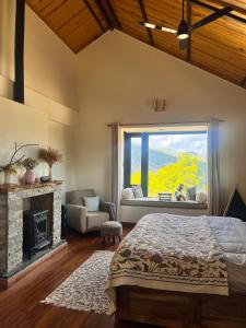 a bedroom with a fireplace and a bed and a window at Jaadooghar The Chitai Life in Almora