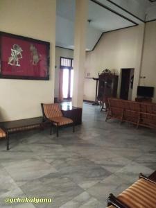 科贾扬Grha Kalyana Homestay的大房间设有椅子和墙上的大画