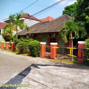 科贾扬Grha Kalyana Homestay的街道前有围栏的房子