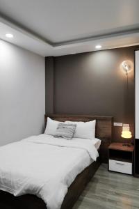 une chambre avec un grand lit avec des draps blancs dans l'établissement The An House Dalat, à Đà Lạt
