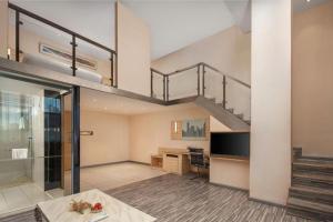 un salon avec un escalier dans un loft dans l'établissement City Comfort Inn Liuzhou Chengzhong Wanda Plaza, à Liuzhou